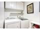 Functional laundry room with washer, dryer, and overhead cabinets at 3315 E Malapai Dr, Phoenix, AZ 85028