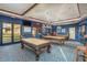 The community billiards room offers three tables, a tv, and bar seating at 42585 W Heavenly Pl, Maricopa, AZ 85138