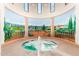 Relaxing hot tub inside a decorative, bright room surrounded by statues, columns, and decorative wall mural at 42585 W Heavenly Pl, Maricopa, AZ 85138