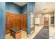 Men's locker room with wood lockers, bench, coat hook, mirror, and bathroom at 42585 W Heavenly Pl, Maricopa, AZ 85138
