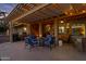 Relaxing patio with fire pit and pergola at night at 42585 W Heavenly Pl, Maricopa, AZ 85138