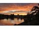 Beautiful sunset reflecting on the lake in this community with houses in the background at 42585 W Heavenly Pl, Maricopa, AZ 85138