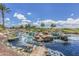 Scenic community water feature featuring rocks, lush landscaping, and clear blue water at 42585 W Heavenly Pl, Maricopa, AZ 85138