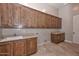 Laundry room with wood cabinets and a built-in sink at 8437 W Park View Ct, Peoria, AZ 85383