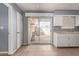 Kitchen with white cabinets, tile floor, and access to patio at 9459 N 111Th Ave, Sun City, AZ 85351