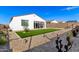 Artificial turf backyard with a sunroom and desert landscaping at 17765 W Silverwood Dr, Goodyear, AZ 85338