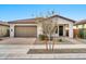Tan colored house with a two-car garage and nicely landscaped yard at 19436 S 208Th Pl, Queen Creek, AZ 85142