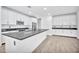 Modern kitchen with white cabinets, dark countertops, and a large island at 19436 S 208Th Pl, Queen Creek, AZ 85142