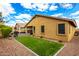 Landscaped backyard with artificial turf and a view of the home's exterior at 20472 N 90Th Ln, Peoria, AZ 85382