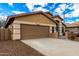 Tan house with a two-car garage and desert landscaping at 20472 N 90Th Ln, Peoria, AZ 85382
