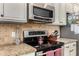 Gas cooktop, microwave, and granite countertop in kitchen at 20472 N 90Th Ln, Peoria, AZ 85382