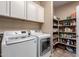 Laundry room with washer, dryer, and storage shelves at 20472 N 90Th Ln, Peoria, AZ 85382