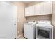 Laundry room with washer, dryer, and overhead cabinets at 20472 N 90Th Ln, Peoria, AZ 85382