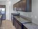 Spacious kitchen featuring granite countertops and dark wood cabinets at 26520 N 132Nd Ln, Peoria, AZ 85383