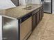 Kitchen island with granite countertop and stainless steel dishwasher at 26520 N 132Nd Ln, Peoria, AZ 85383