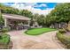 Landscaped backyard oasis with putting green and outdoor kitchen at 3731 E Halifax Cir, Mesa, AZ 85205