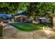 Expansive backyard with putting green, fire pit, and covered patio at 3731 E Halifax Cir, Mesa, AZ 85205