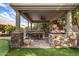 Covered outdoor kitchen with pizza oven, grill, and bar seating at 3731 E Halifax Cir, Mesa, AZ 85205