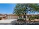 Charming home exterior with a three car garage, desert landscaping, and beautiful mature shade tree at 4119 S Las Villa Way, Gold Canyon, AZ 85118