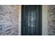 Close up of a sleek, ornate, secure, metal front door surrounded by stone detailing at 4119 S Las Villa Way, Gold Canyon, AZ 85118