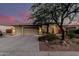 Attractive single-story home with a three-car garage, stone accents, and lush desert landscaping, enhancing its curb appeal at 4119 S Las Villa Way, Gold Canyon, AZ 85118