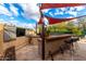 Covered outdoor kitchen with bar seating and shade sails at 4119 S Las Villa Way, Gold Canyon, AZ 85118