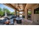 Covered patio area features travertine flooring, plush outdoor seating, and outdoor kitchen and pool at 4119 S Las Villa Way, Gold Canyon, AZ 85118