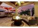 Relaxing outdoor area with a covered patio, comfortable seating, a bar, and a cozy fire pit for cool evenings at 4119 S Las Villa Way, Gold Canyon, AZ 85118