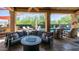 Luxurious covered patio featuring stone columns, travertine floors, comfortable seating, and a pool at 4119 S Las Villa Way, Gold Canyon, AZ 85118