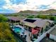 Aerial view of a backyard with a pool, covered patio, and outdoor kitchen surrounded by desert landscape at 4119 S Las Villa Way, Gold Canyon, AZ 85118