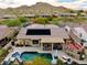 Aerial view of a backyard with a pool, covered patio, and outdoor kitchen, showing the solar panels on the roof at 4119 S Las Villa Way, Gold Canyon, AZ 85118