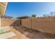Small backyard with block wall, gate, and covered patio at 8908 W Loma Ln, Peoria, AZ 85345
