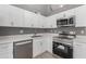 Modern kitchen featuring white cabinets, stainless steel appliances, and quartz countertops at 8908 W Loma Ln, Peoria, AZ 85345