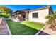 Landscaped backyard with artificial turf and a covered patio at 10141 E Stealth Ave, Mesa, AZ 85212