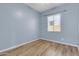 Light blue bedroom with wood-look floors and window at 10141 E Stealth Ave, Mesa, AZ 85212