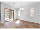 Bright dining room features wood-look flooring, neutral paint, backyard access, and a modern chandelier at 10141 E Stealth Ave, Mesa, AZ 85212