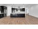 Modern kitchen boasts a center island, stainless steel appliances, dark cabinets, and beautiful flooring at 10141 E Stealth Ave, Mesa, AZ 85212