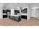 Open kitchen features stainless appliances, large island, dark cabinets, and modern fixtures at 10141 E Stealth Ave, Mesa, AZ 85212
