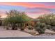 Desert home with a welcoming arched entry and beautifully landscaped yard at 10175 E Winter Sun Dr, Scottsdale, AZ 85262