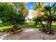 Landscaped backyard with mature trees and stone patio at 10314 W Manzanita Dr, Sun City, AZ 85373