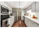 Bright galley kitchen with white cabinets, stainless appliances and wood floors at 10314 W Manzanita Dr, Sun City, AZ 85373