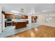 Open kitchen with wood cabinets, granite counters, island, and hardwood floors at 10873 W Carlota Ln, Peoria, AZ 85373