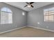 Well-lit bedroom featuring two windows and a ceiling fan at 1112 E Newland Dr, Chandler, AZ 85286