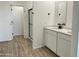 Bathroom features dual sinks with white cabinets, a large mirror, and a glass-enclosed shower at 24098 W Sunland Ave, Buckeye, AZ 85326