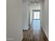 Hallway with wood-style flooring leads to living area and bright, natural light from sliding glass door at 24098 W Sunland Ave, Buckeye, AZ 85326