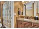 Clean bathroom with granite vanity, shower, and patterned curtain at 2458 E Roma Ave, Phoenix, AZ 85016