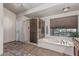 Bathroom with a bathtub, shower, and neutral earthy tones at 3457 E Ellis St, Mesa, AZ 85213