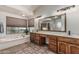 Bathroom featuring a large vanity, bathtub, and a window overlooking greenery at 3457 E Ellis St, Mesa, AZ 85213
