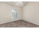 Bedroom featuring neutral walls, carpet, and a unique arched window with white shutters at 3457 E Ellis St, Mesa, AZ 85213