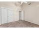 Neutral bedroom features carpeted floors, a ceiling fan, and closet with double doors at 3457 E Ellis St, Mesa, AZ 85213